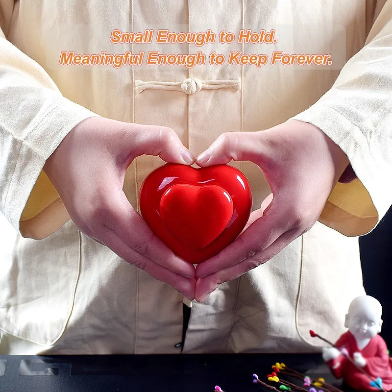 Palm-sized heart-shaped ceramic pet urn held in one hand