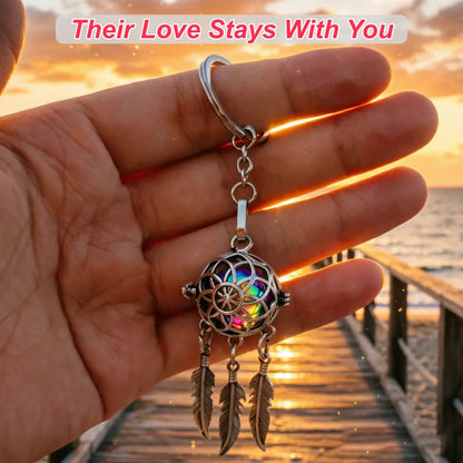 Pet ashes keepsake dreamcatcher keychain held in hand against a warm sunset background